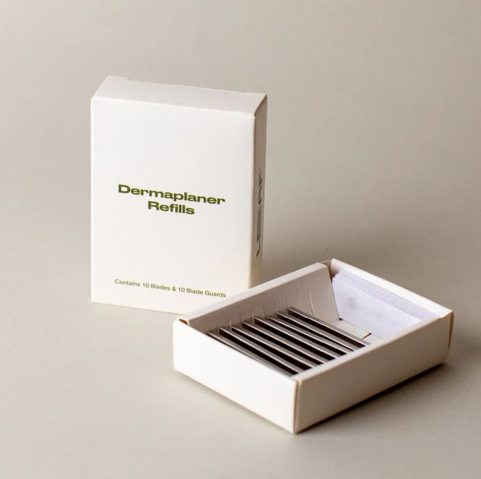 Dermaplaner refills in an open box with packaging labeled 'Dermaplaner Refills' on a neutral background.