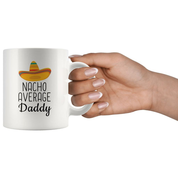 Hand holding a white Nacho Average Daddy mug by its handle