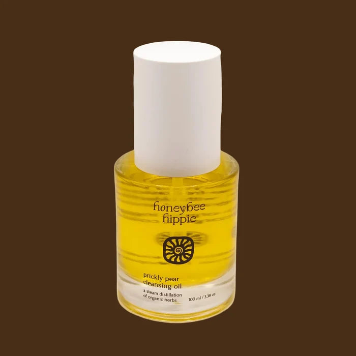 Bottle of honeybee hippie pickly pear cleansing oil on a beige background